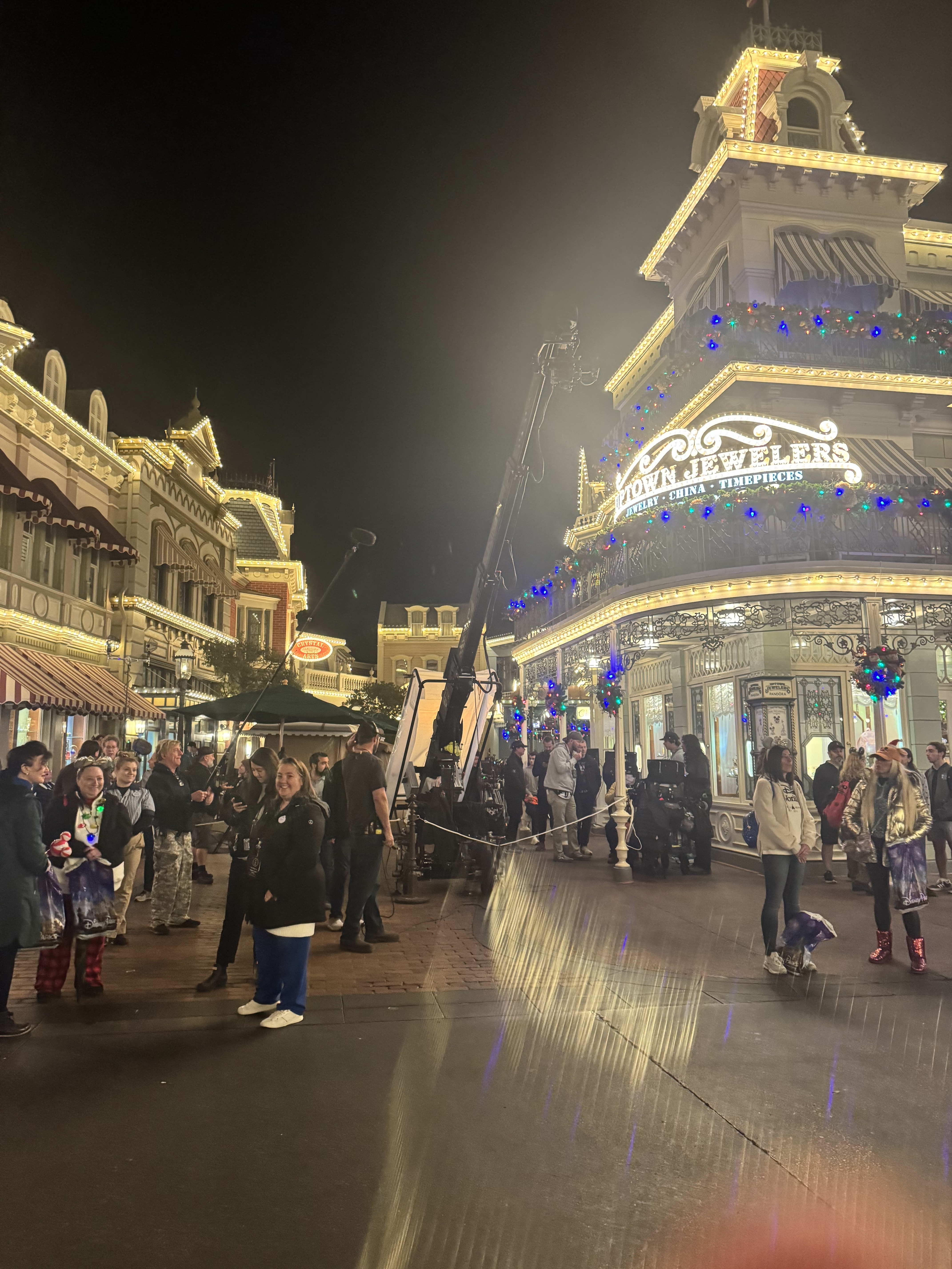 A film crew and camera crane on Main Street at night during the Hallmark Christmas movie filming