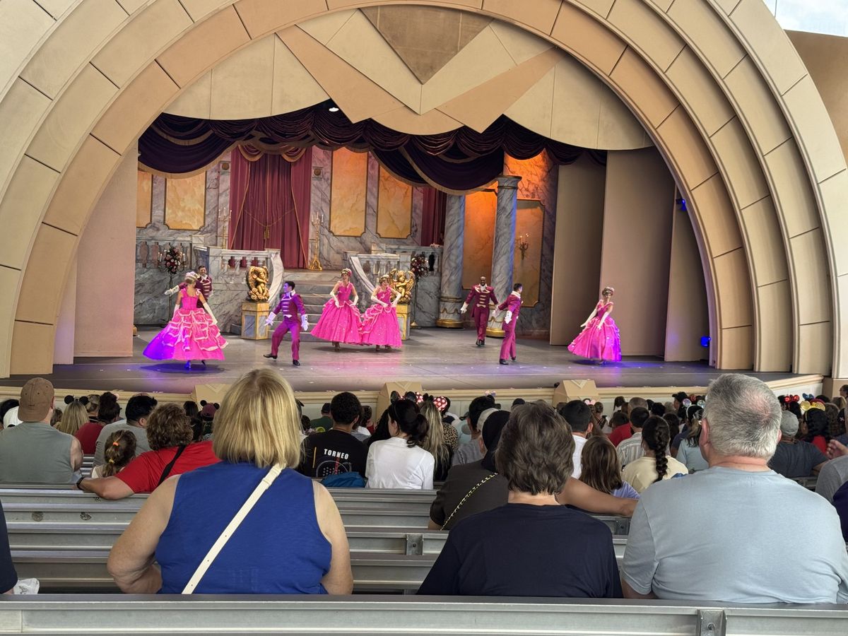 The cast of Beauty and the Beast Live on Stage dancing in pink gowns