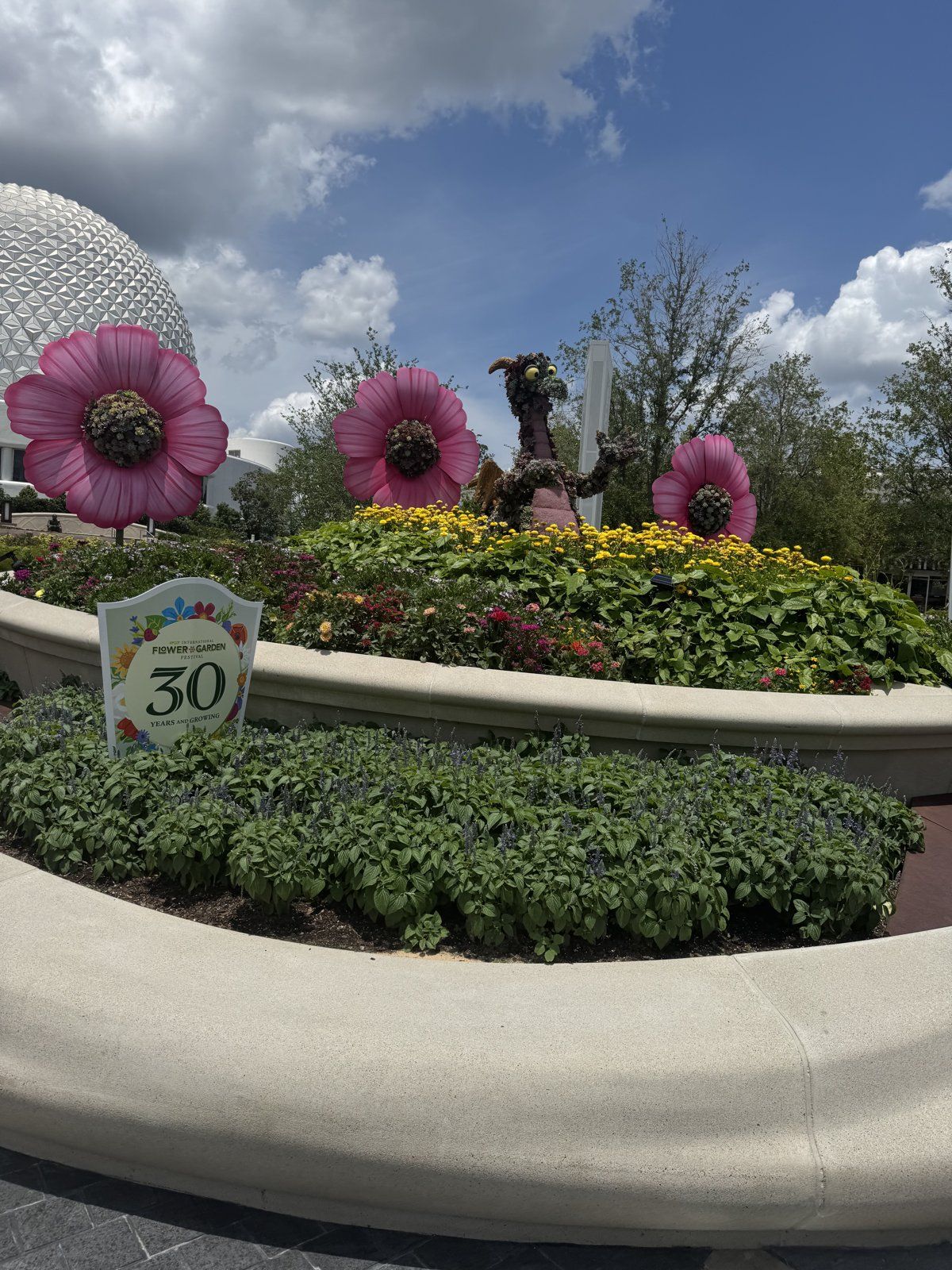 Festival flowers in bloom with Spaceship Earth peeking out behind them
