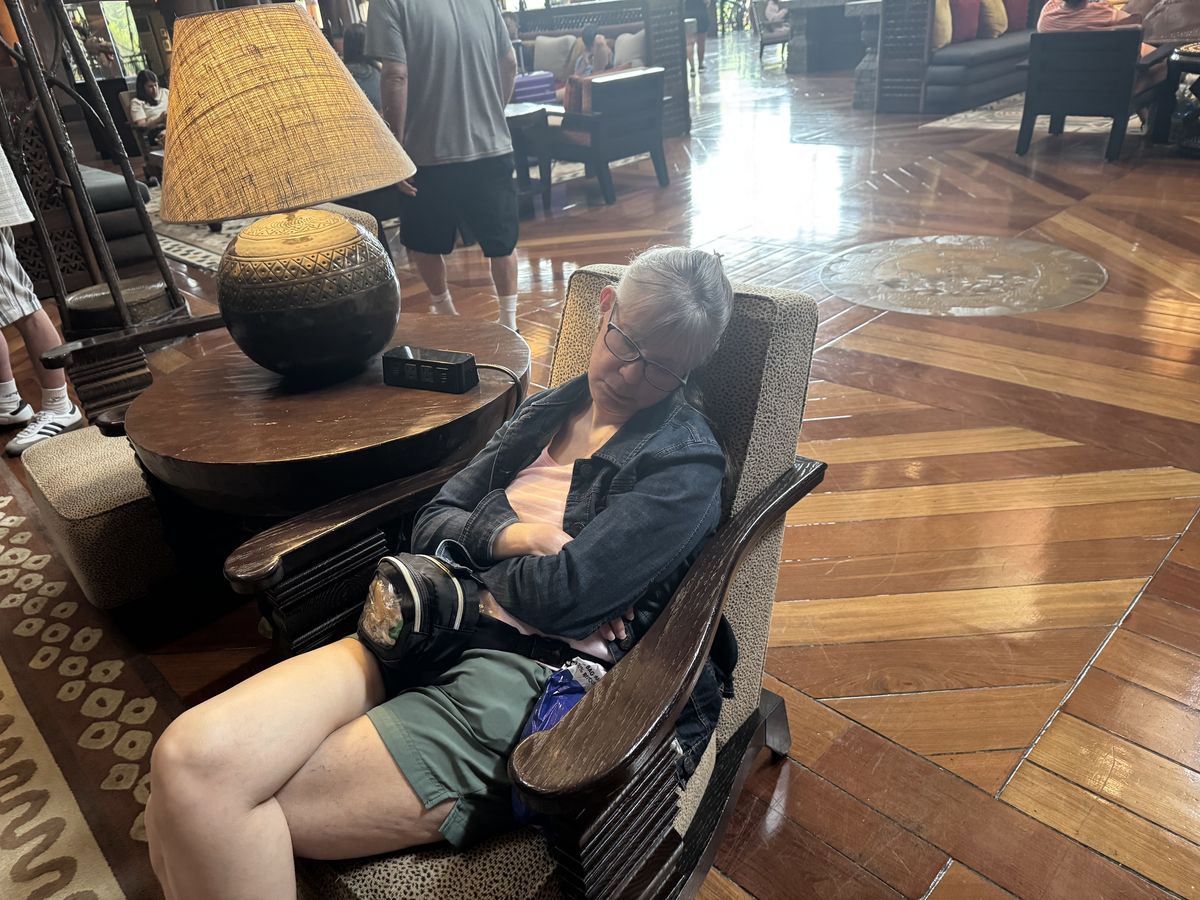 Moms fallen asleep in a lobby chair during the Animal Kingdom Lodge art tour